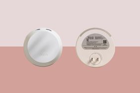 Two sides of a smoke detector one showing the front and the other the back with a battery compartment