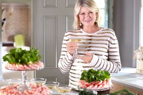 martha holding cocktails by table of seafood