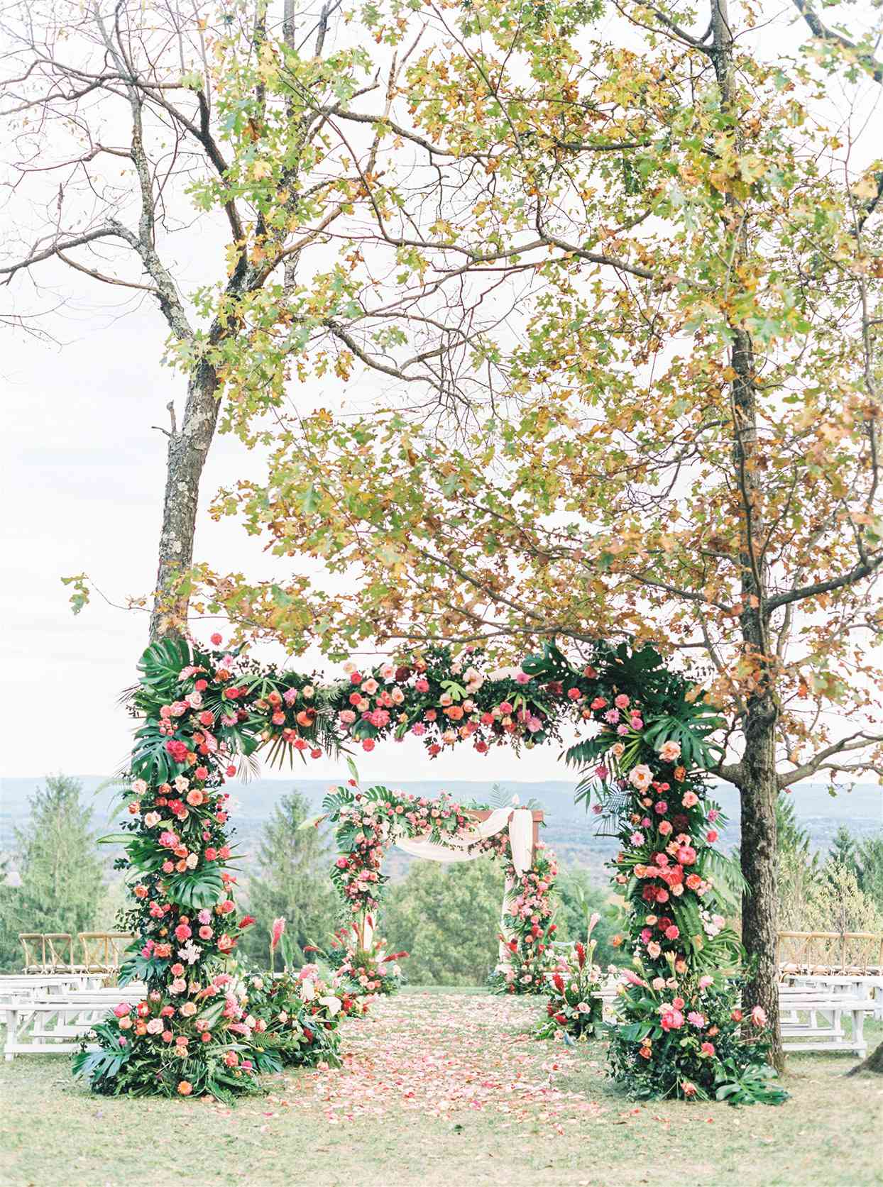outdoor fall wedding setting with floral arches and petal walkway