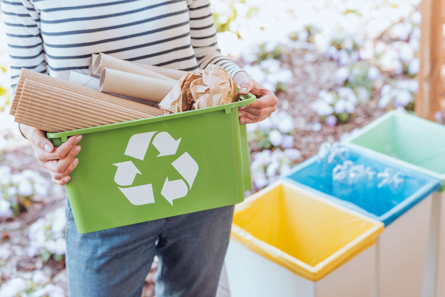 woman carrying recycle bin