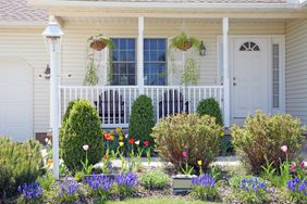 Pretty vinyl clad ranch home with Amish made chairs on the porch, and lovely Spring landscaped yard.