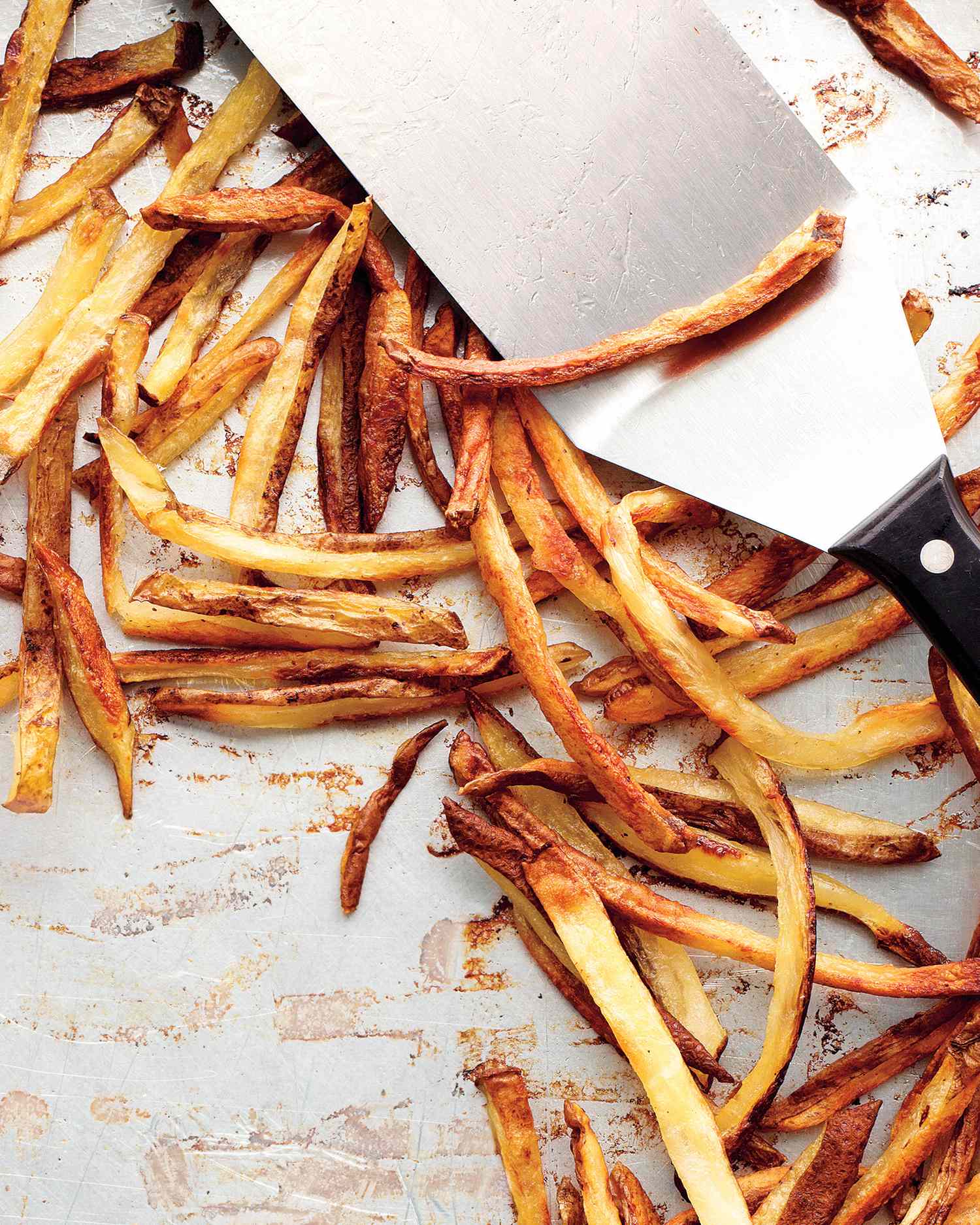 oven fries on baking sheet with spatula