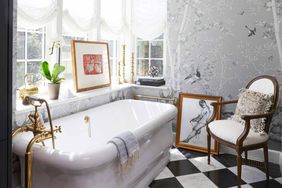 Luxurious bathroom featuring a freestanding bathtub, elegant decor, and framed artwork