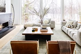 A contemporary living room with large windows a wooden coffee table and modern furniture