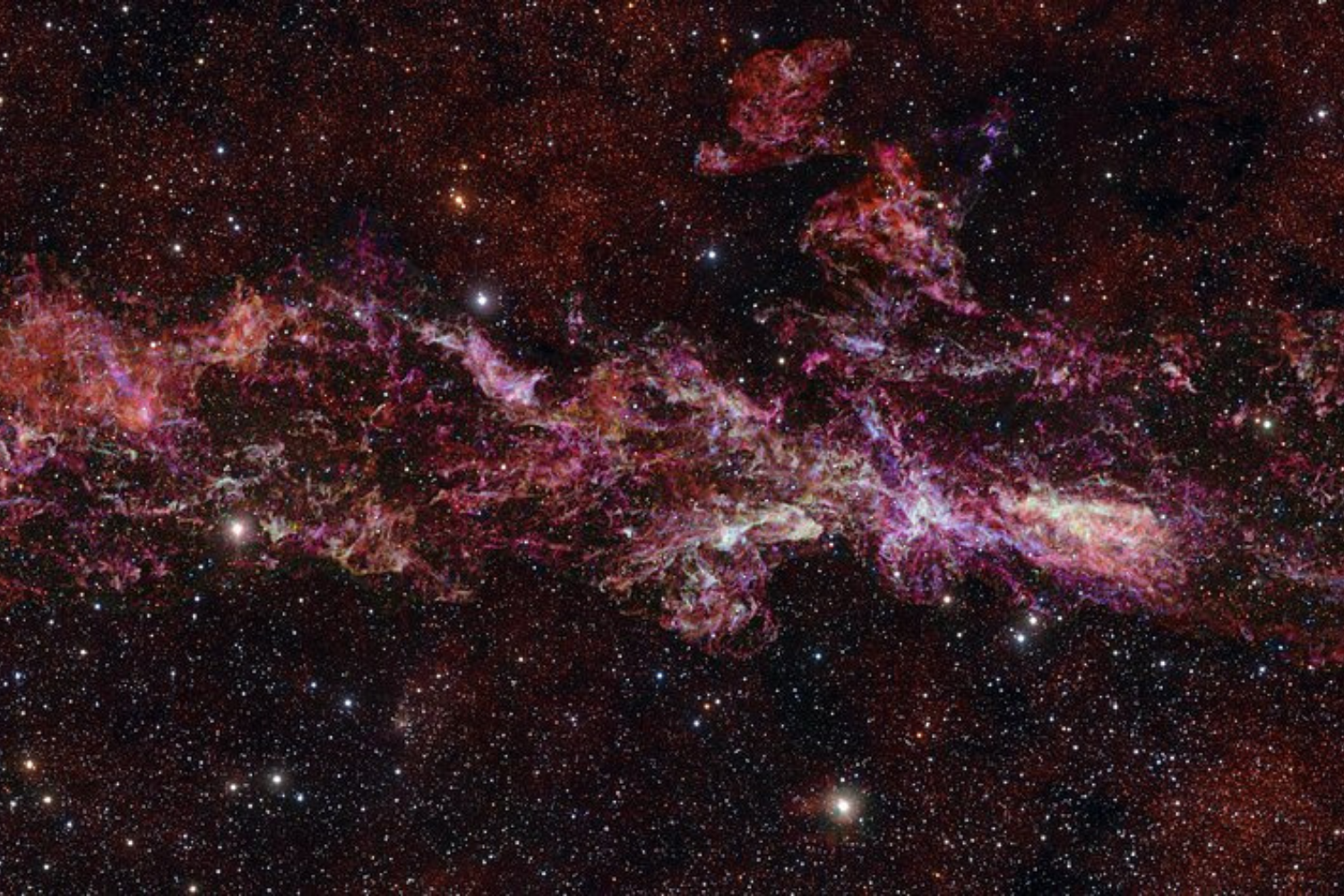 A colorful nebula in outer space with a star field in the background