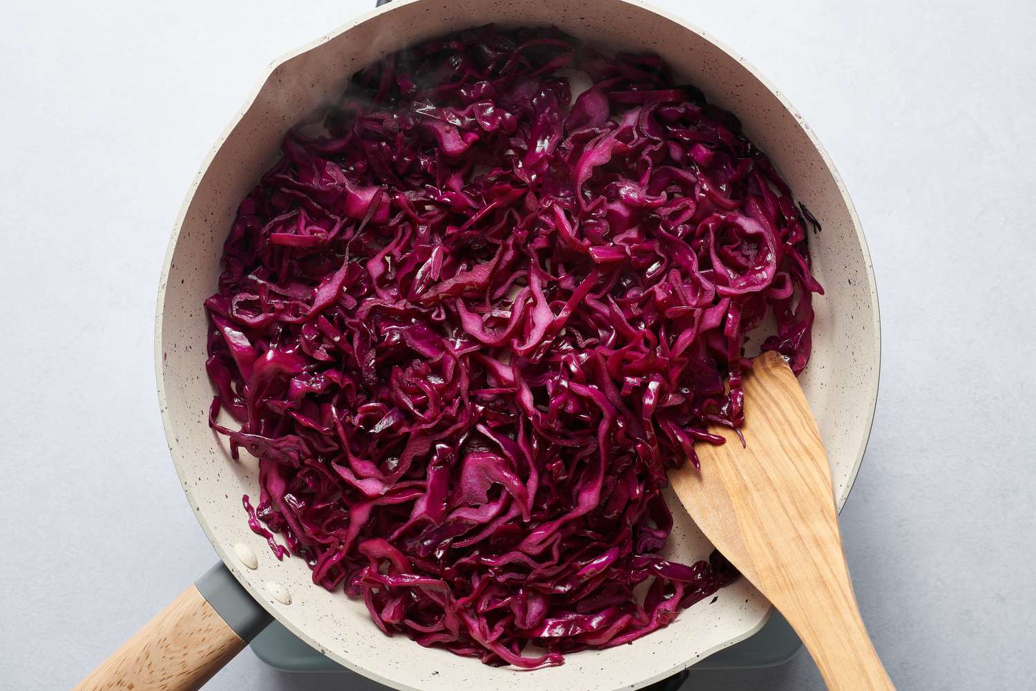 stirring red cabbage in pan as it sautes