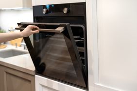 A person opening an oven door