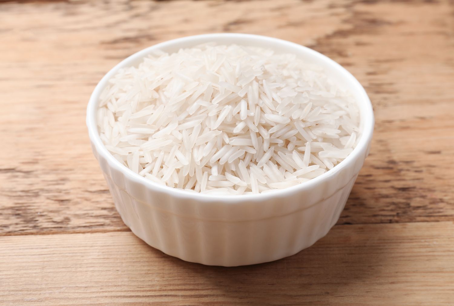 A bowl of rice on a wooden surface
