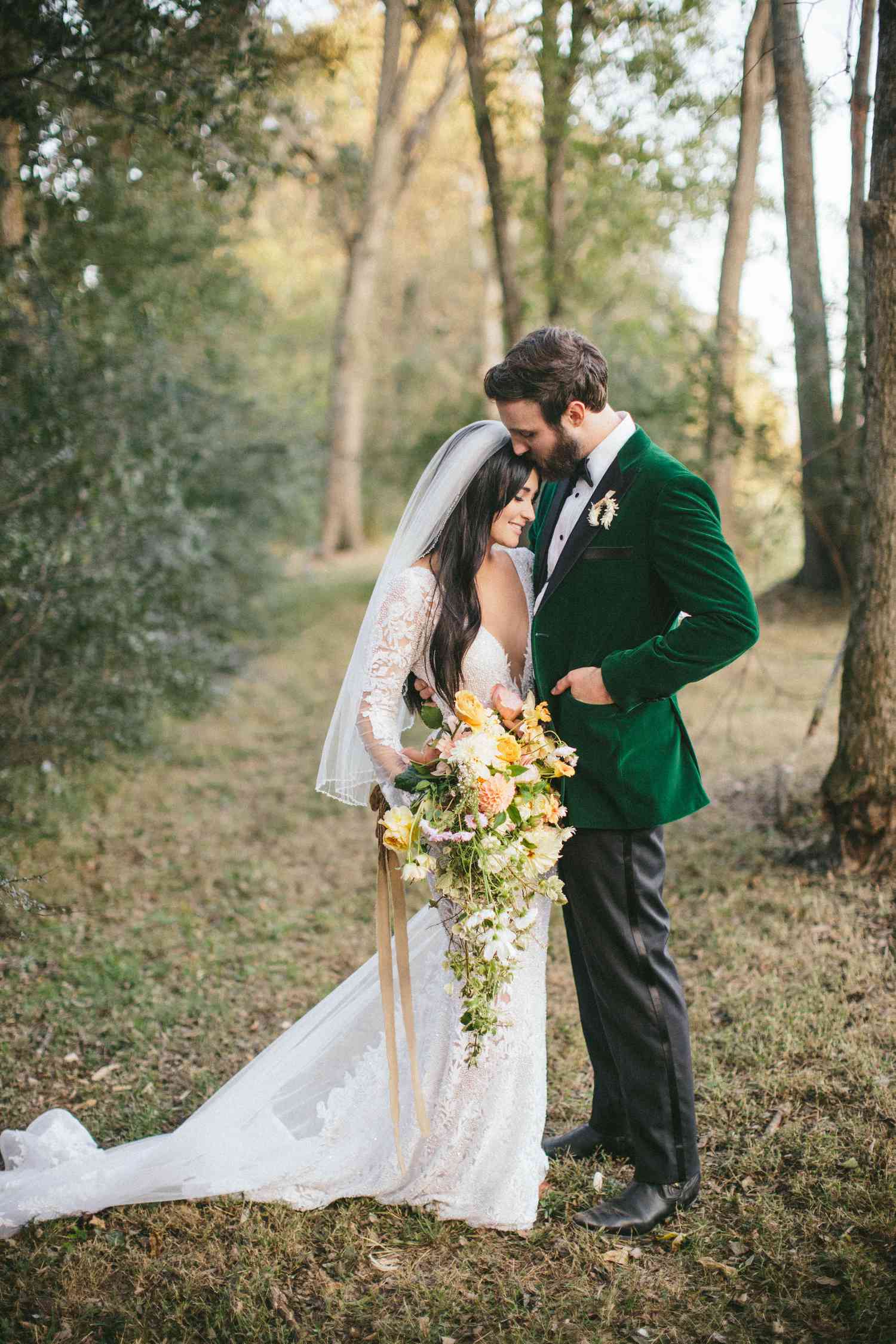 Bride in fingertip wedding veil and groom in green velvet suit