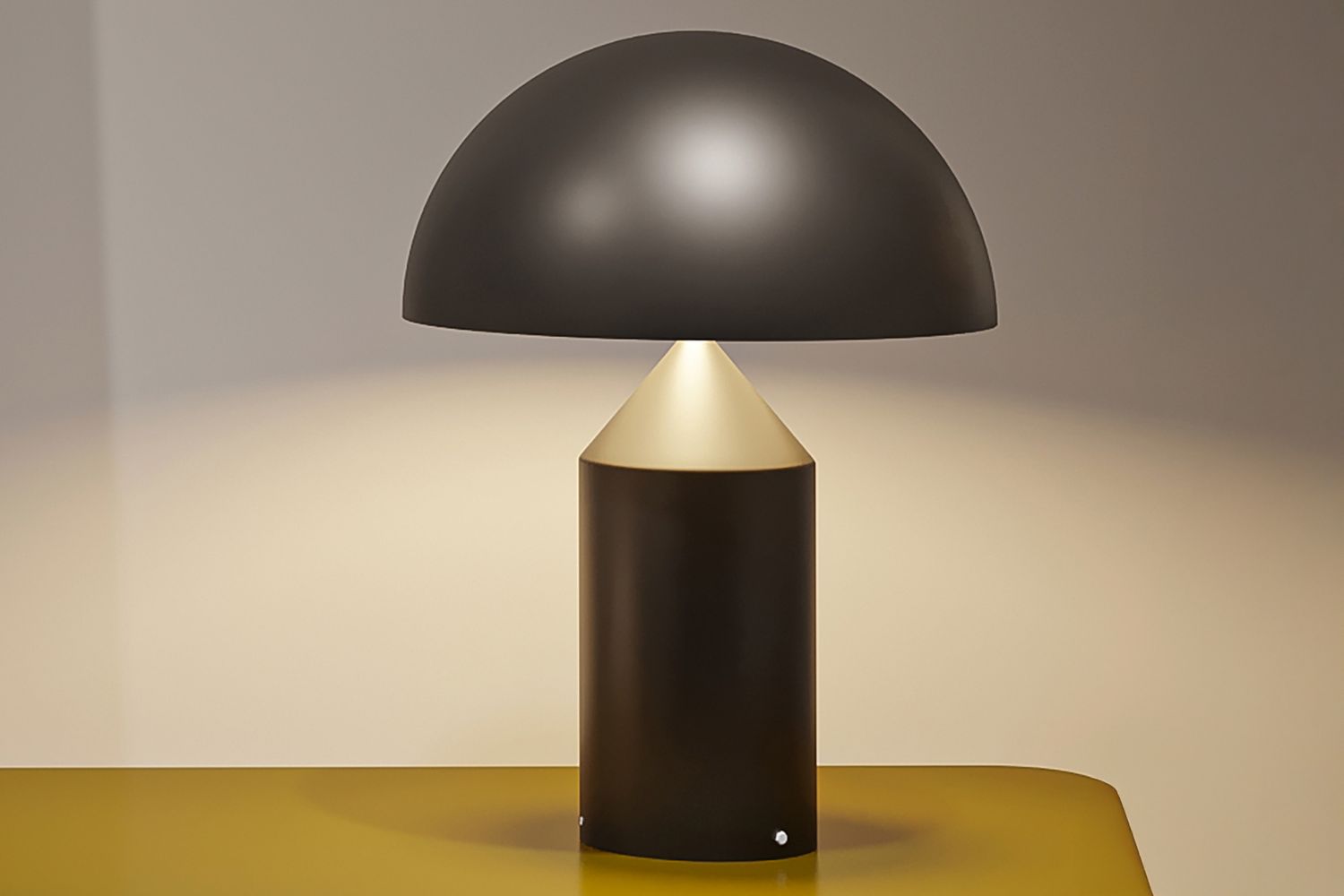 A modern table lamp with a domed top and cylindrical base placed on a surface