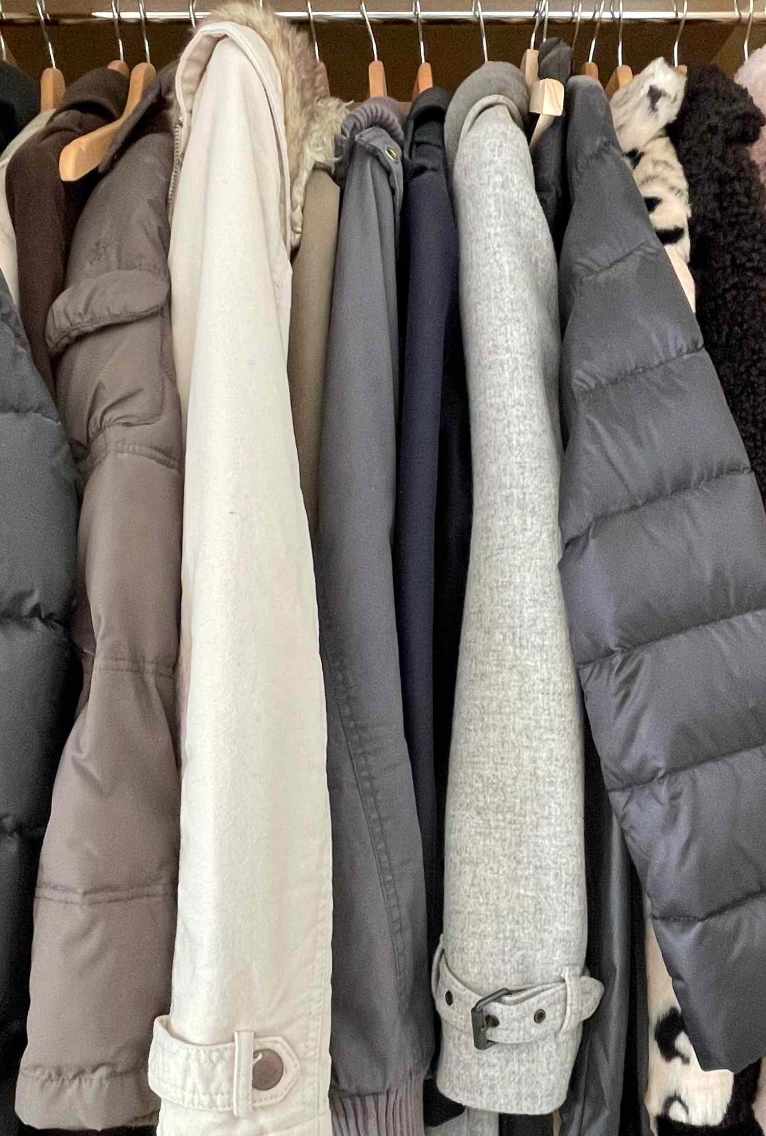 A row of winter coats hanging on a rack