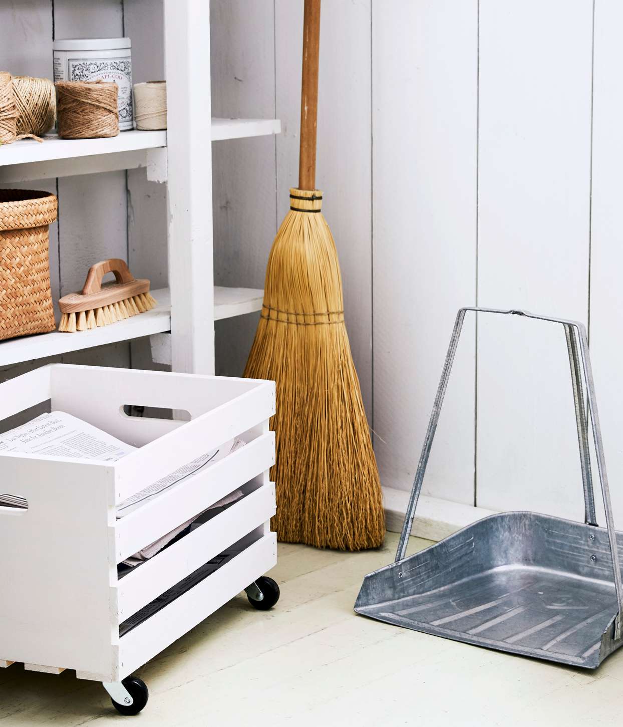 organized cleaning supply closet with broom and dustpan
