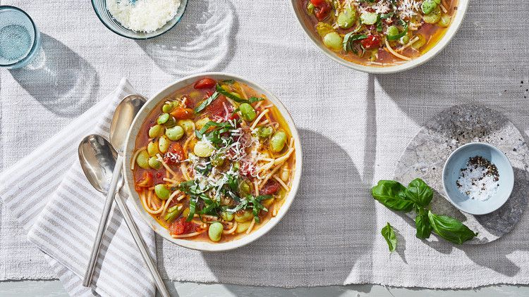 pasta and bean soup served on a table with a gray table cloth