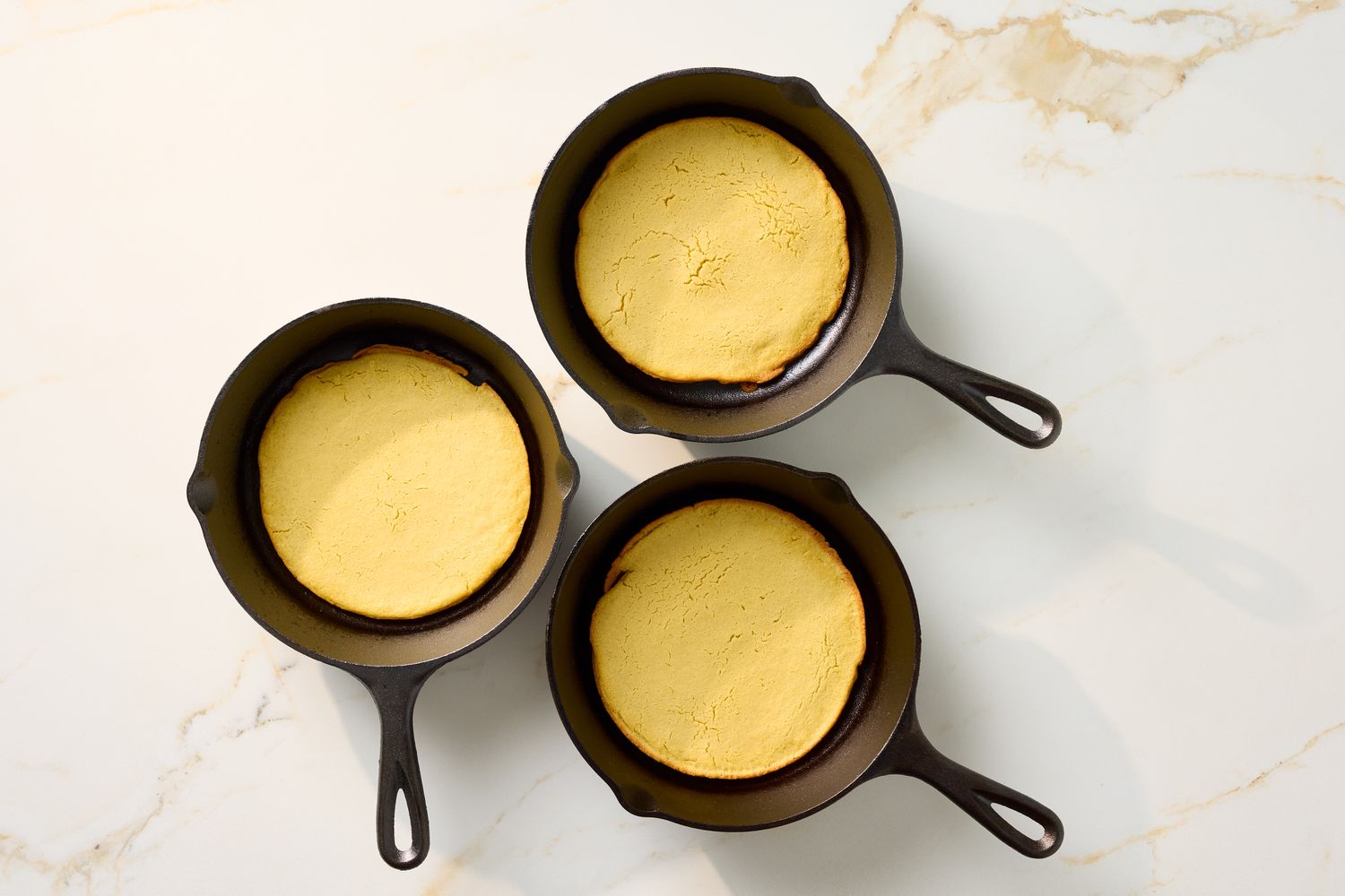 Three cast iron pans with farinata a type of chickpea pancake