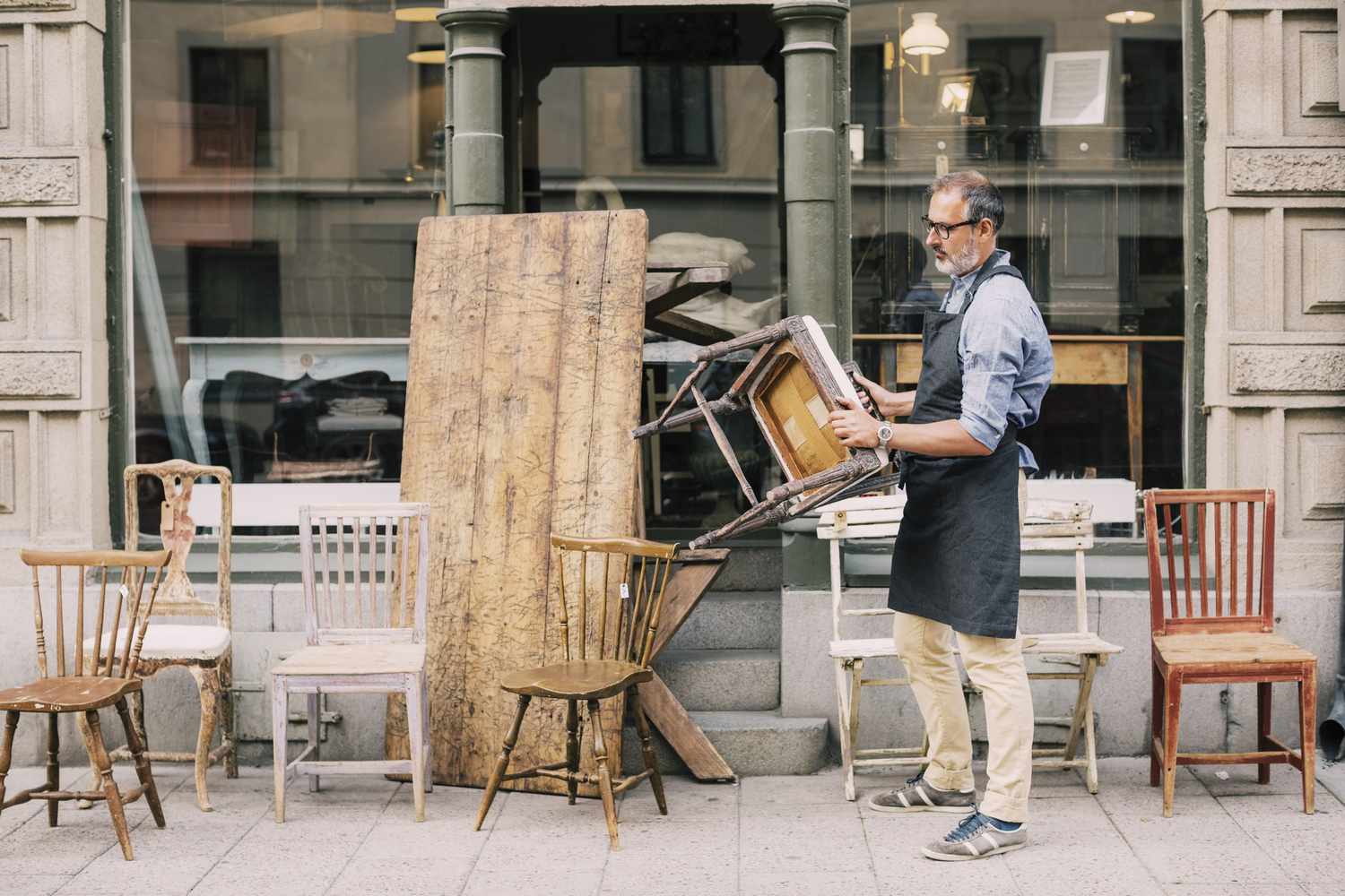 Man setting up thrift store furniture pieces
