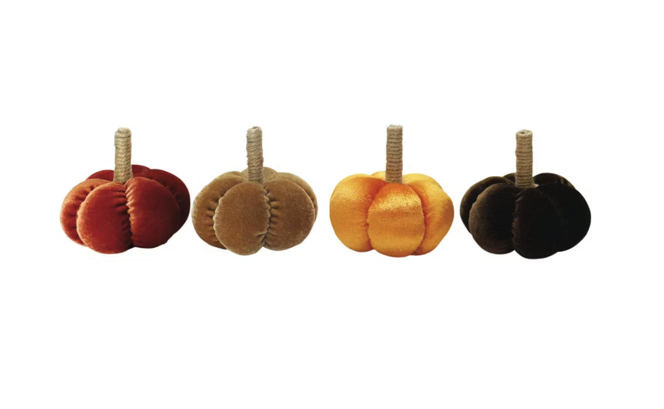 Four plush pumpkins with textured stems arranged in a row