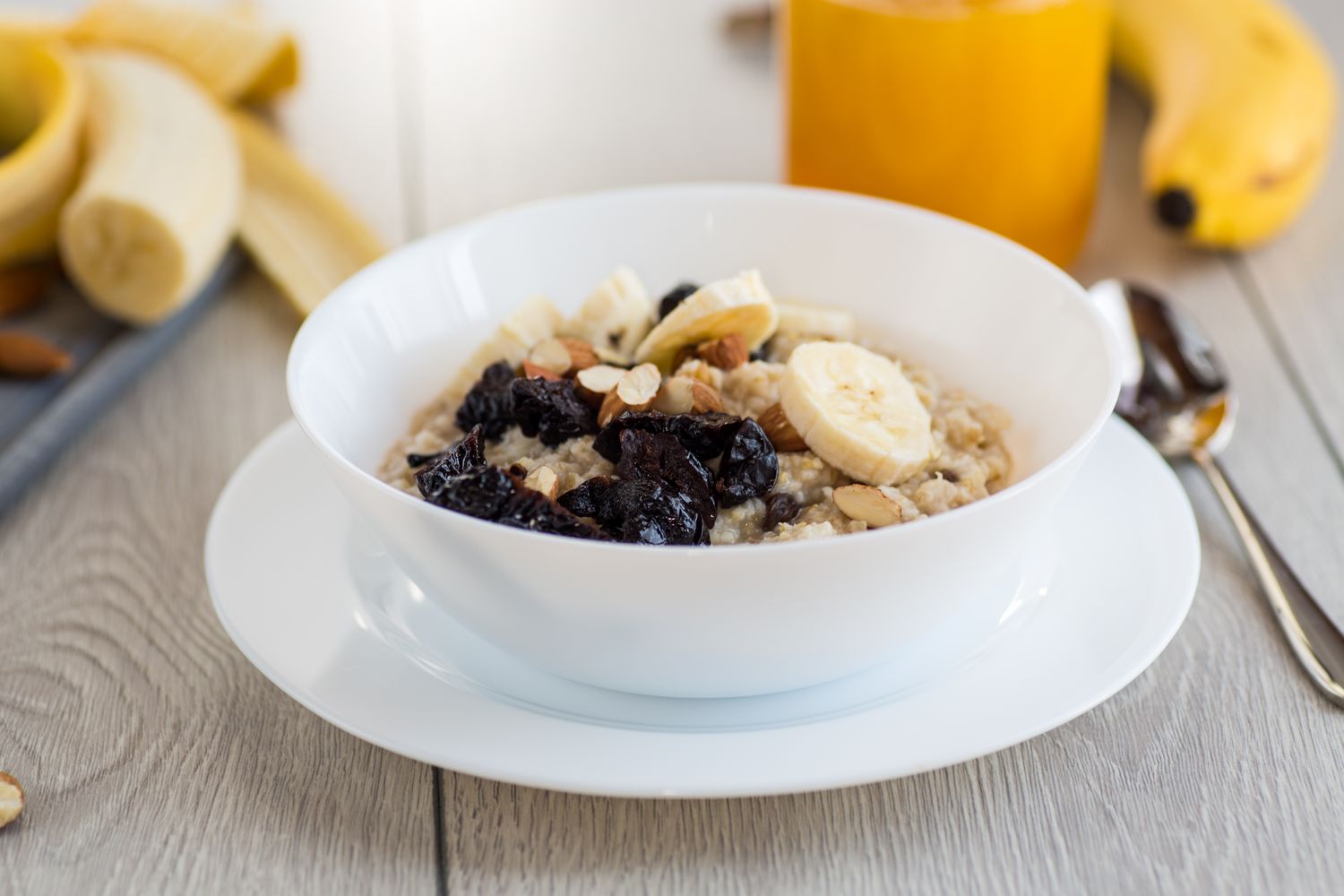Healthy oatmeal with banana, nuts and prunes .