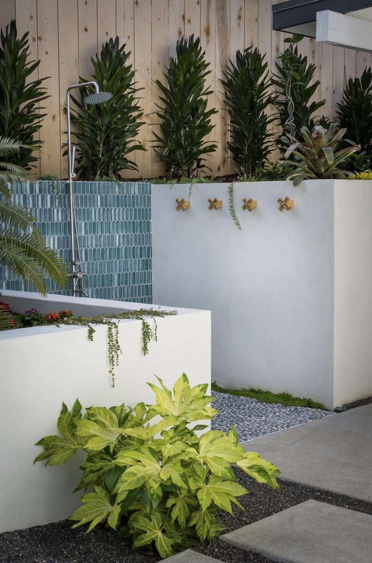 Outdoor shower with blue glass tiles and playful brass hooks