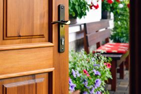 Front door of home open to flowers