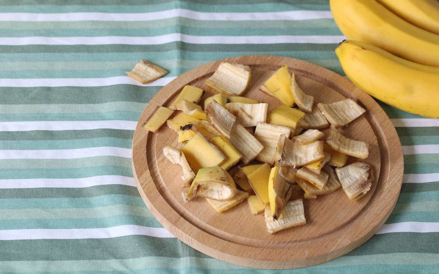 Chopped banana peels are displayed on a wooden cutting board
