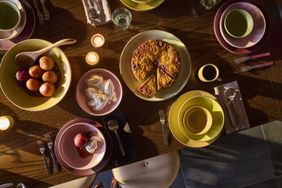 Dining table with served dishes including a pie rolls and plates arranged in a decorative layout