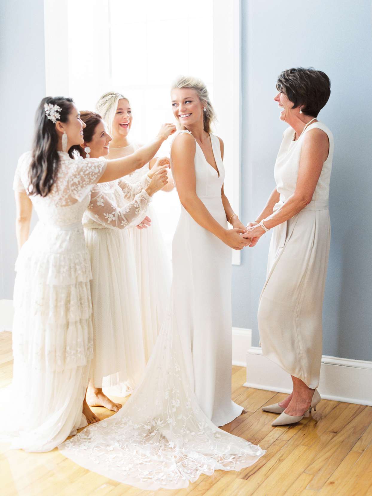 bride with bridesmaids and mother getting ready
