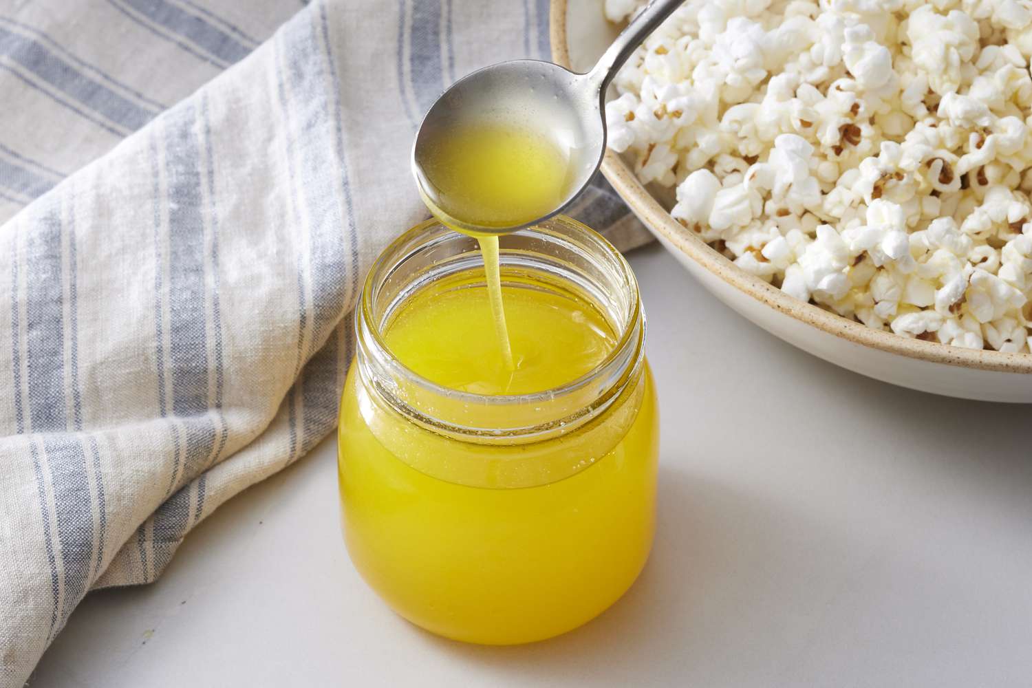 Clarified butter in jar next to popcorn