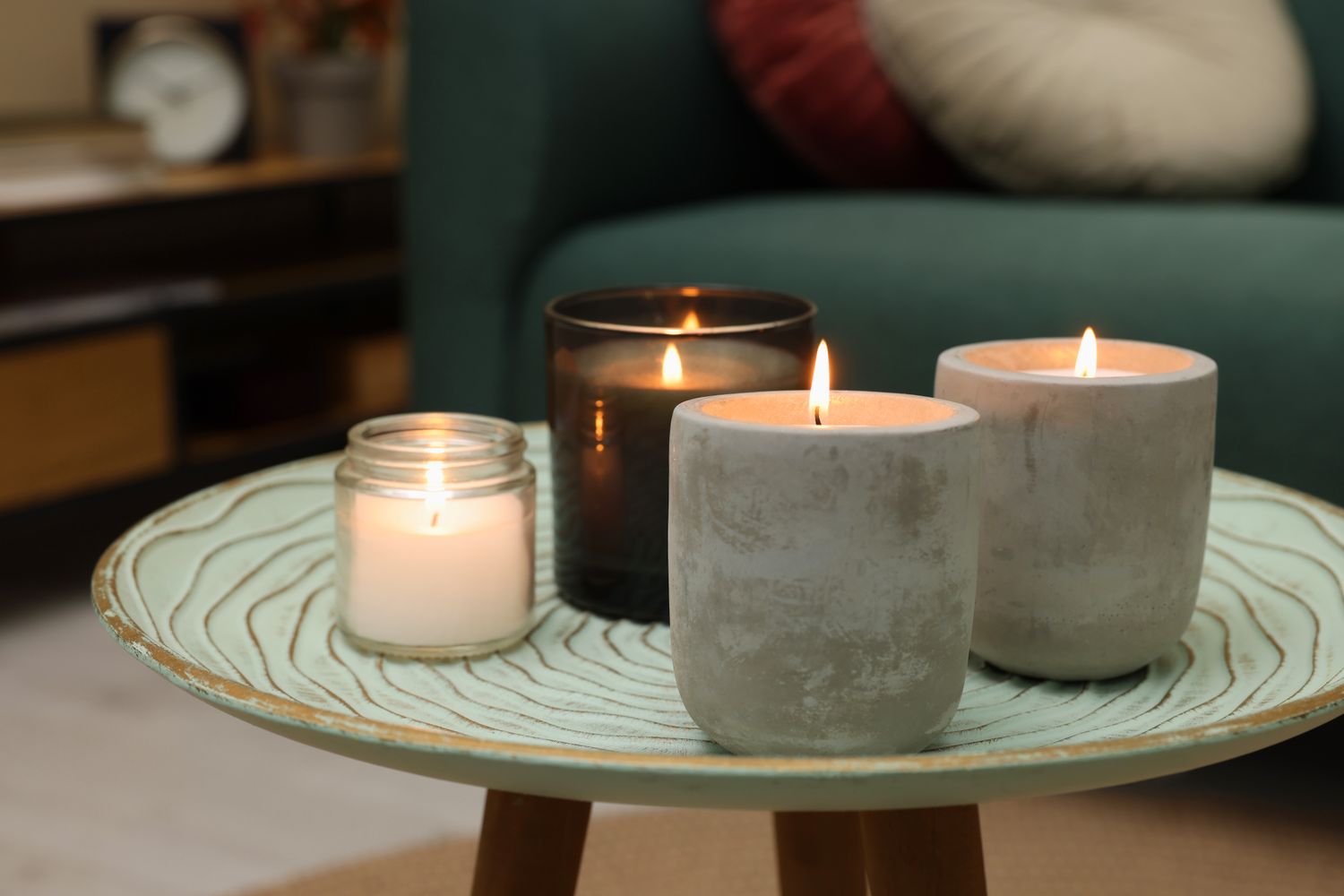 Lit candles on a decorative round table in a cozy living room setting