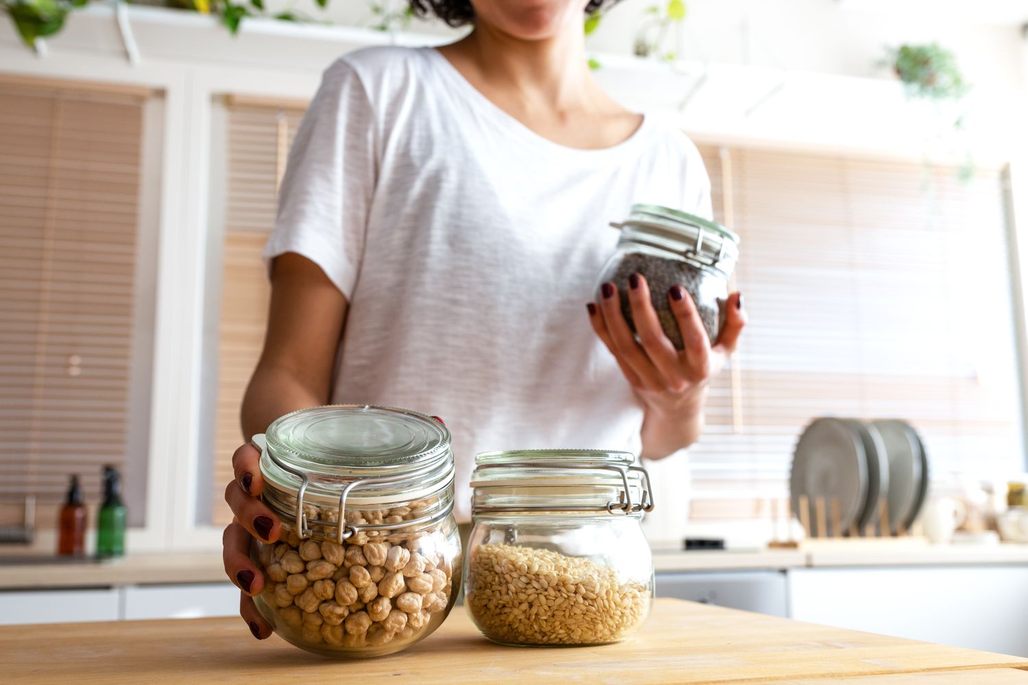 Person holding jars of food ingredients in a kitchen