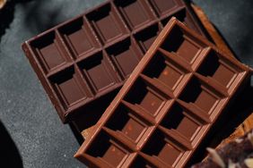 Two chocolate bars arranged on a dark surface
