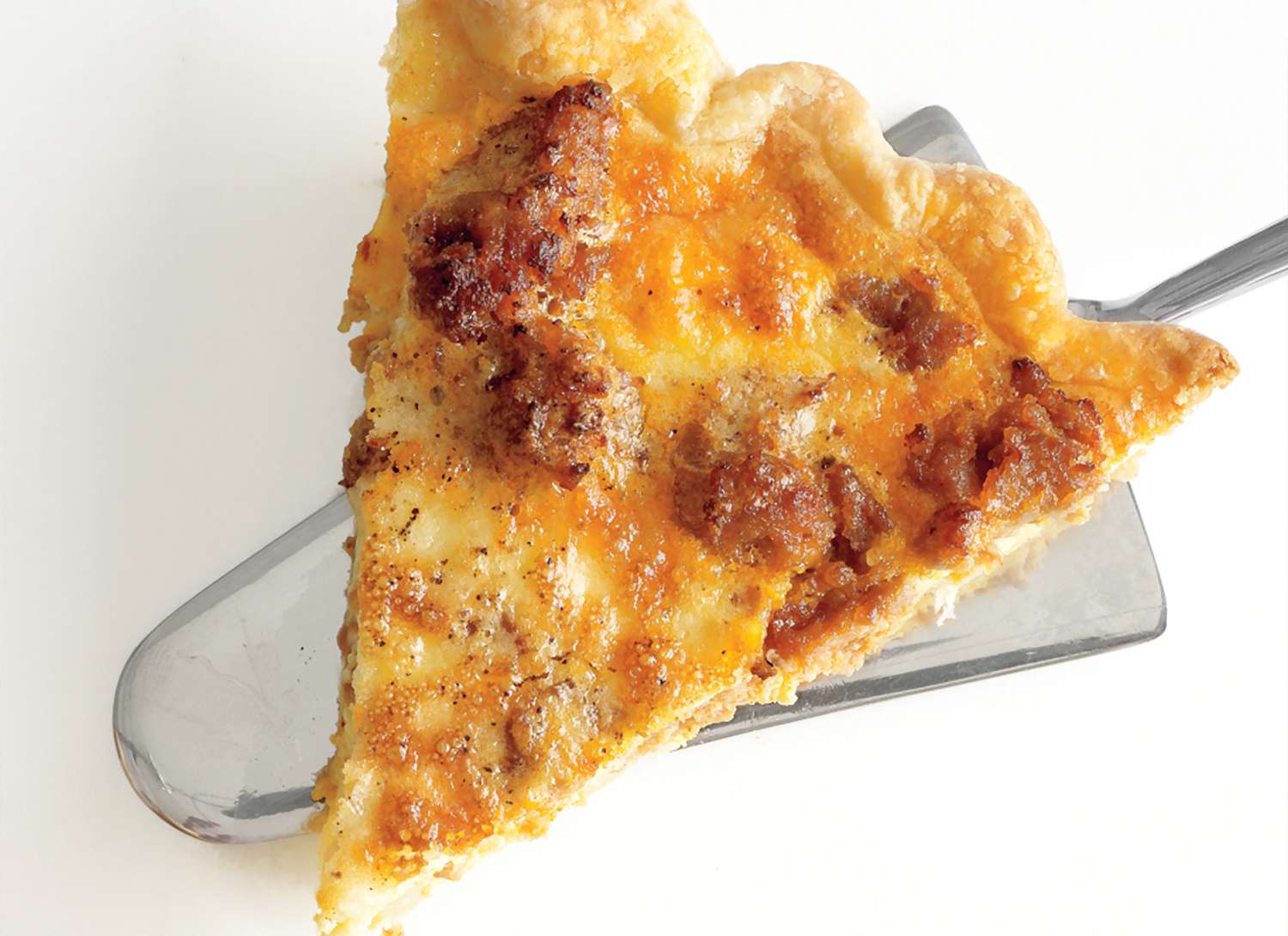 close up of a slice of sausage potato quiche
