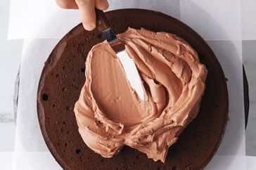 spreading frosting on devils food cake