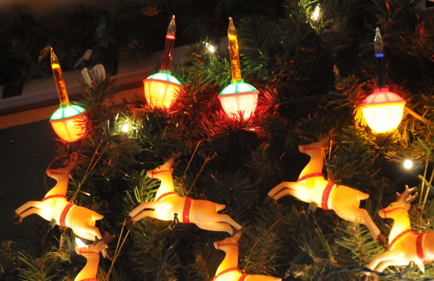 Festive decorations of reindeer and vintagestyle ornament lights on a Christmas tree