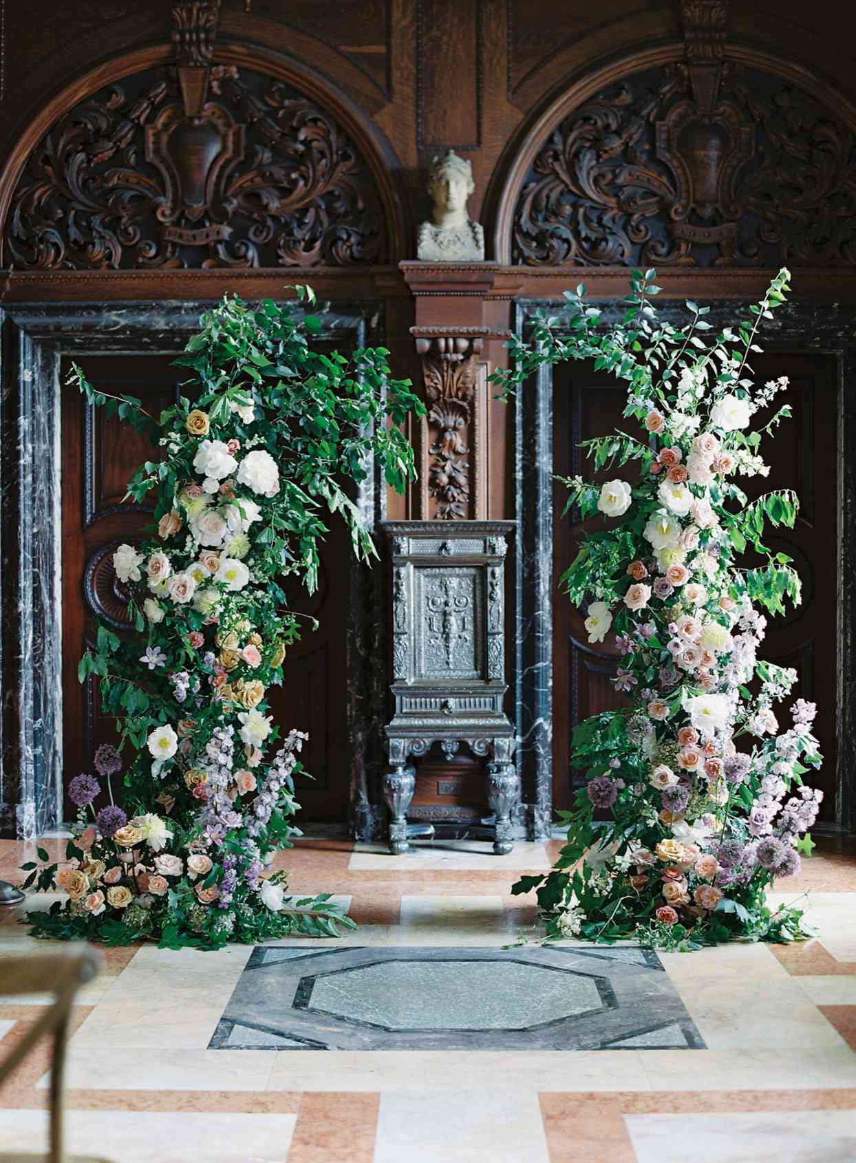 large greenery floral wedding arch indoors