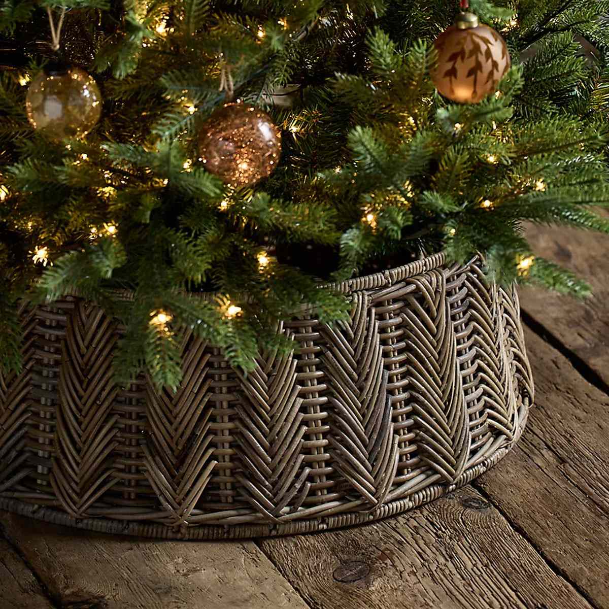 Christmas tree with decorative ornaments and a woven rattan tree skirt