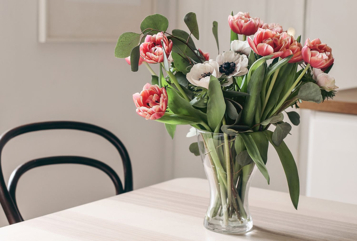 A glass vase with flowers on a table