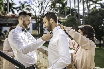 Family helping groom wearing a bowtie