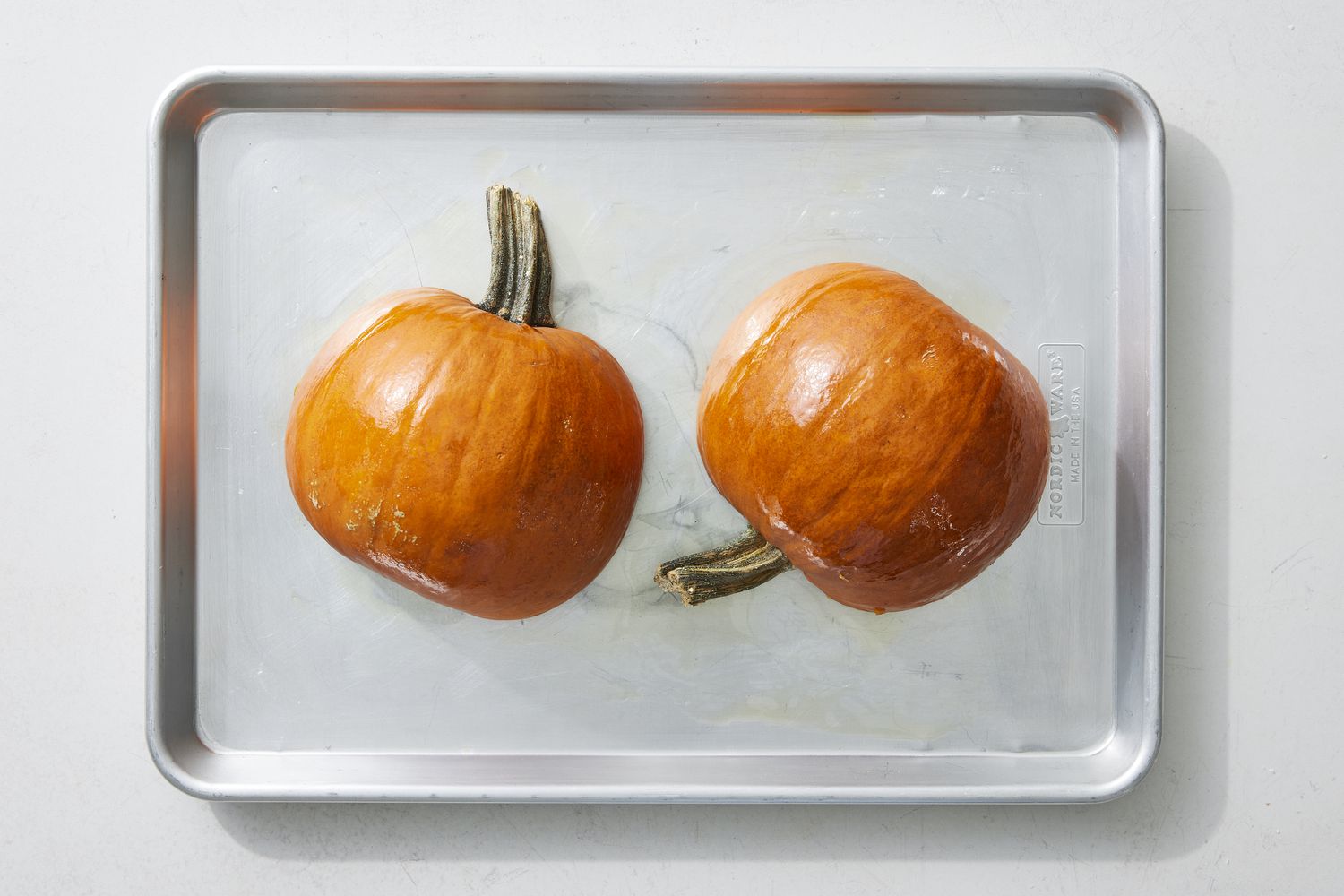 Pumpkin halves on baking sheet