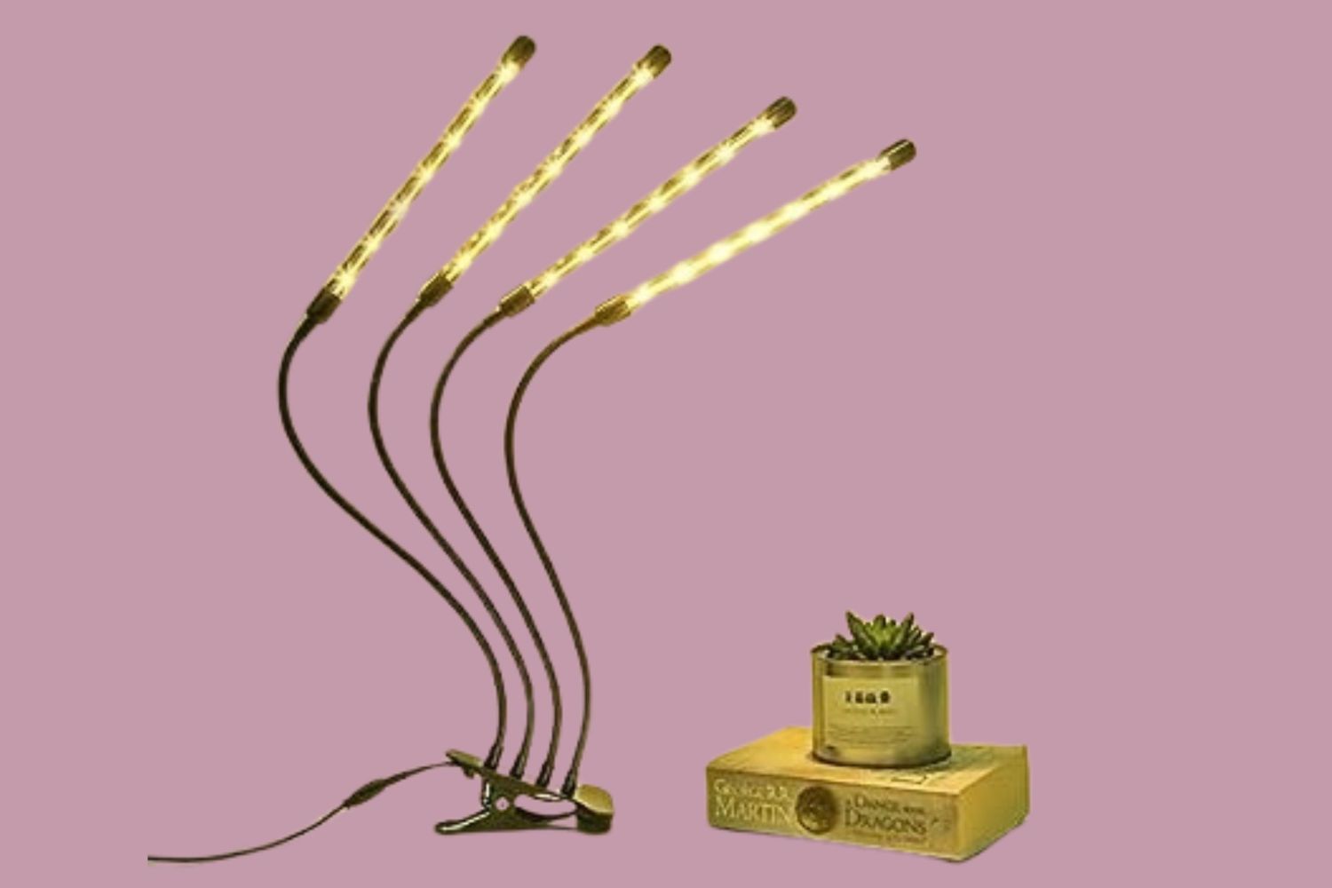 Flexible grow light with four adjustable arms positioned over a potted plant placed on a book