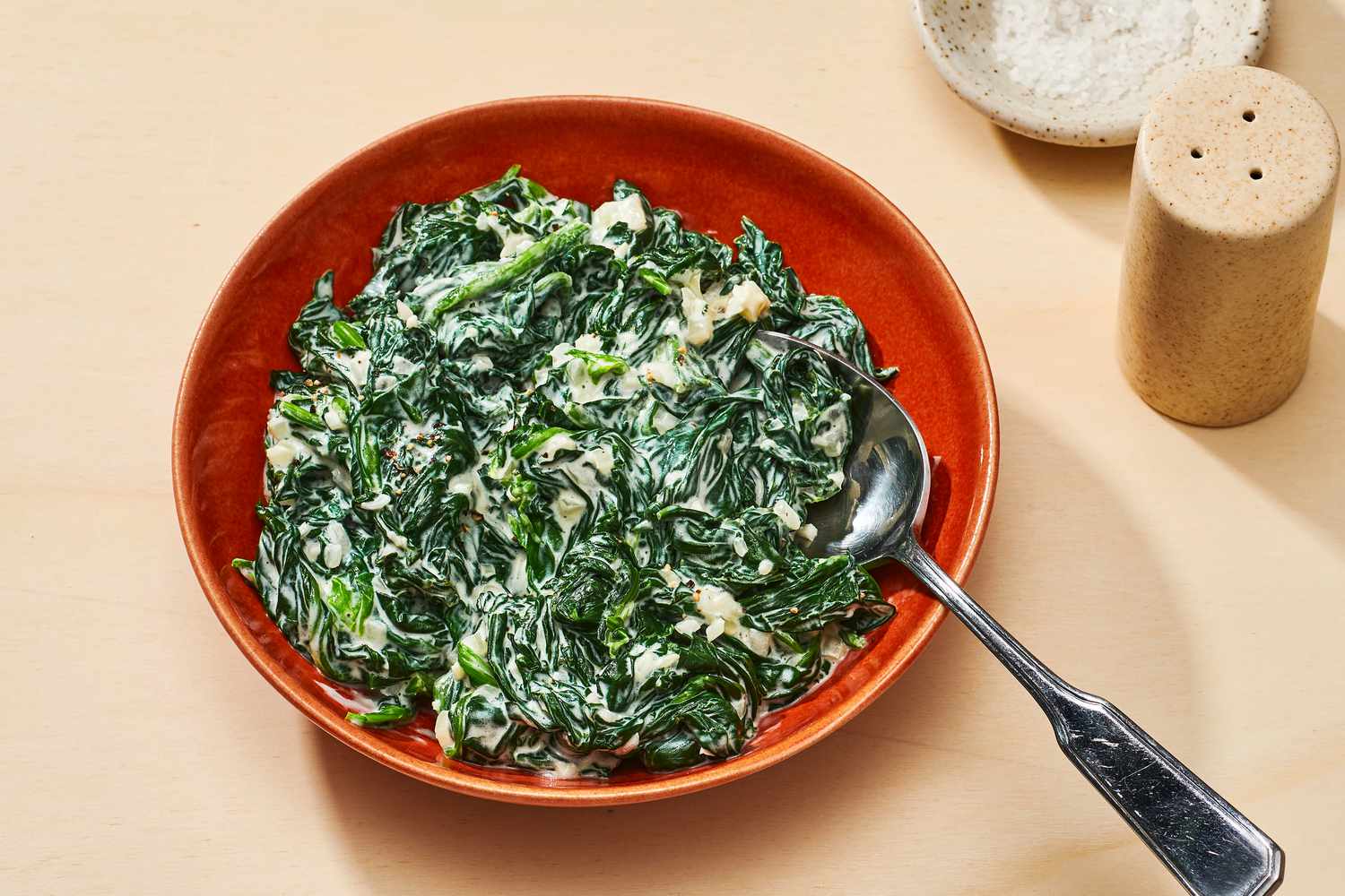easy creamed spinach in red serving bowl