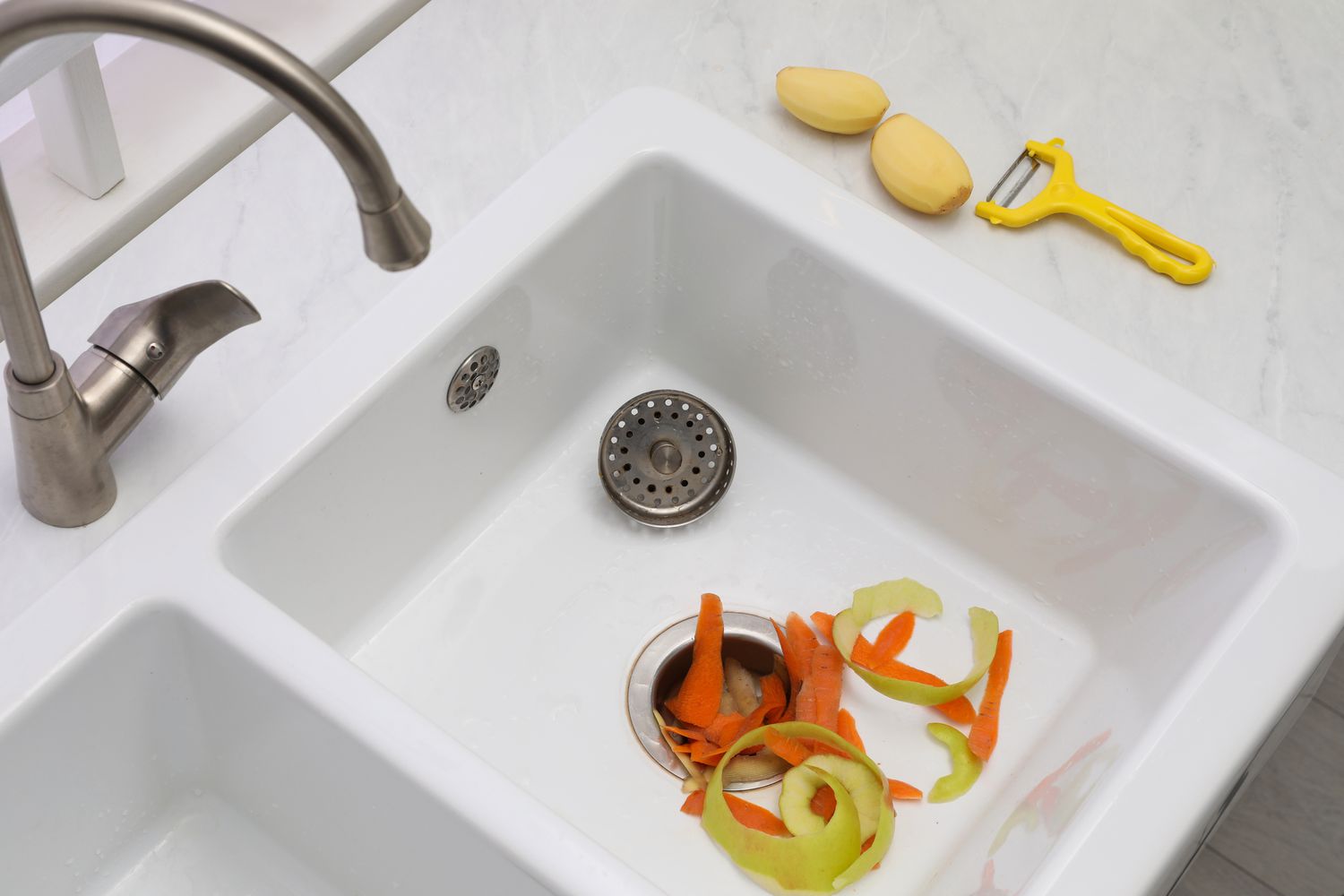 Vegetable scraps in kitchen sink with garbage disposal