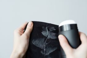 Hands holding fabric with deodorant stains