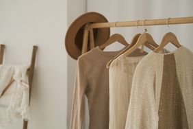 new clothing hanging on a rack in a bedroom