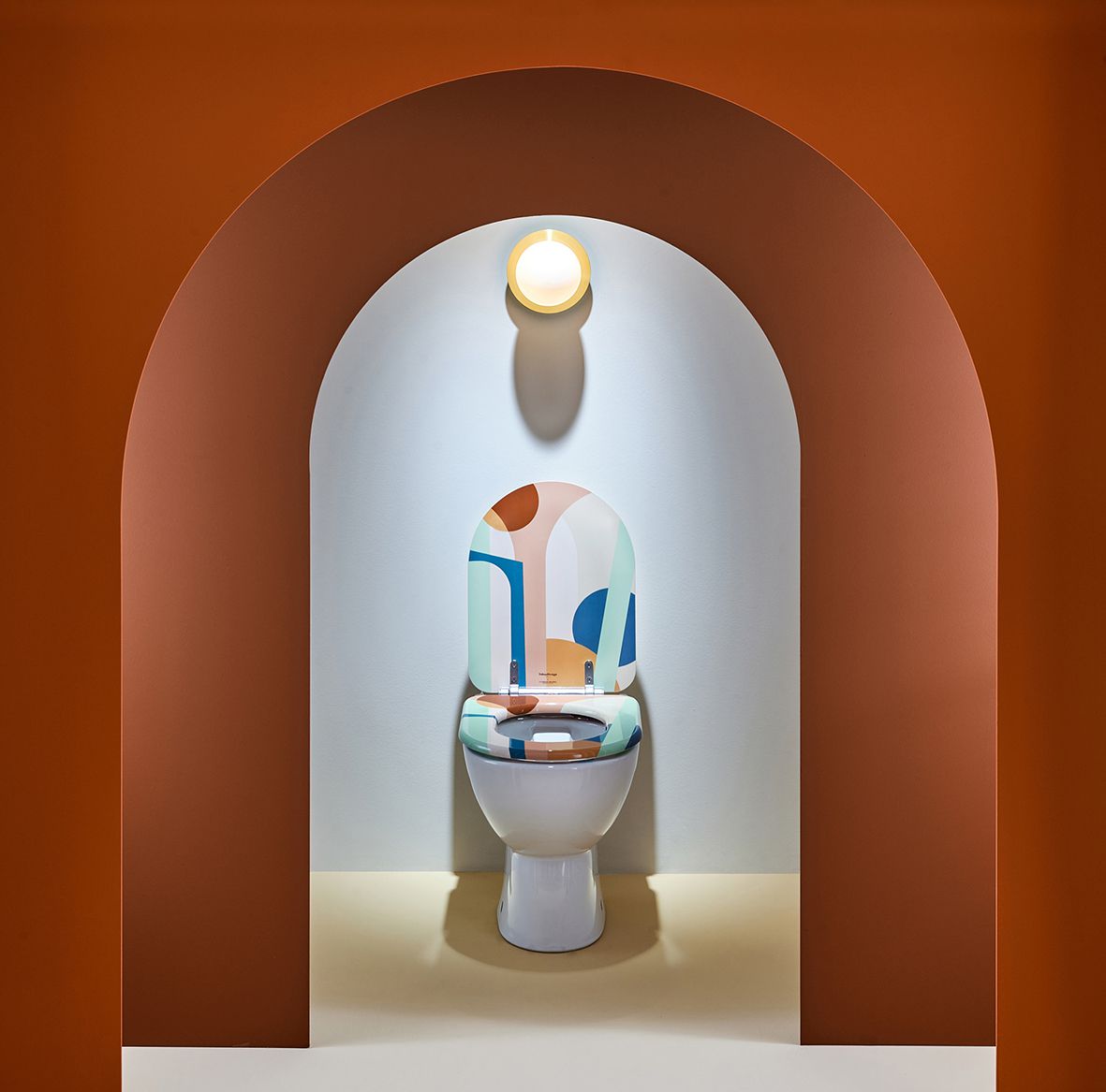 Artistic toilet design with abstract patterns displayed in an arched niche with lighting