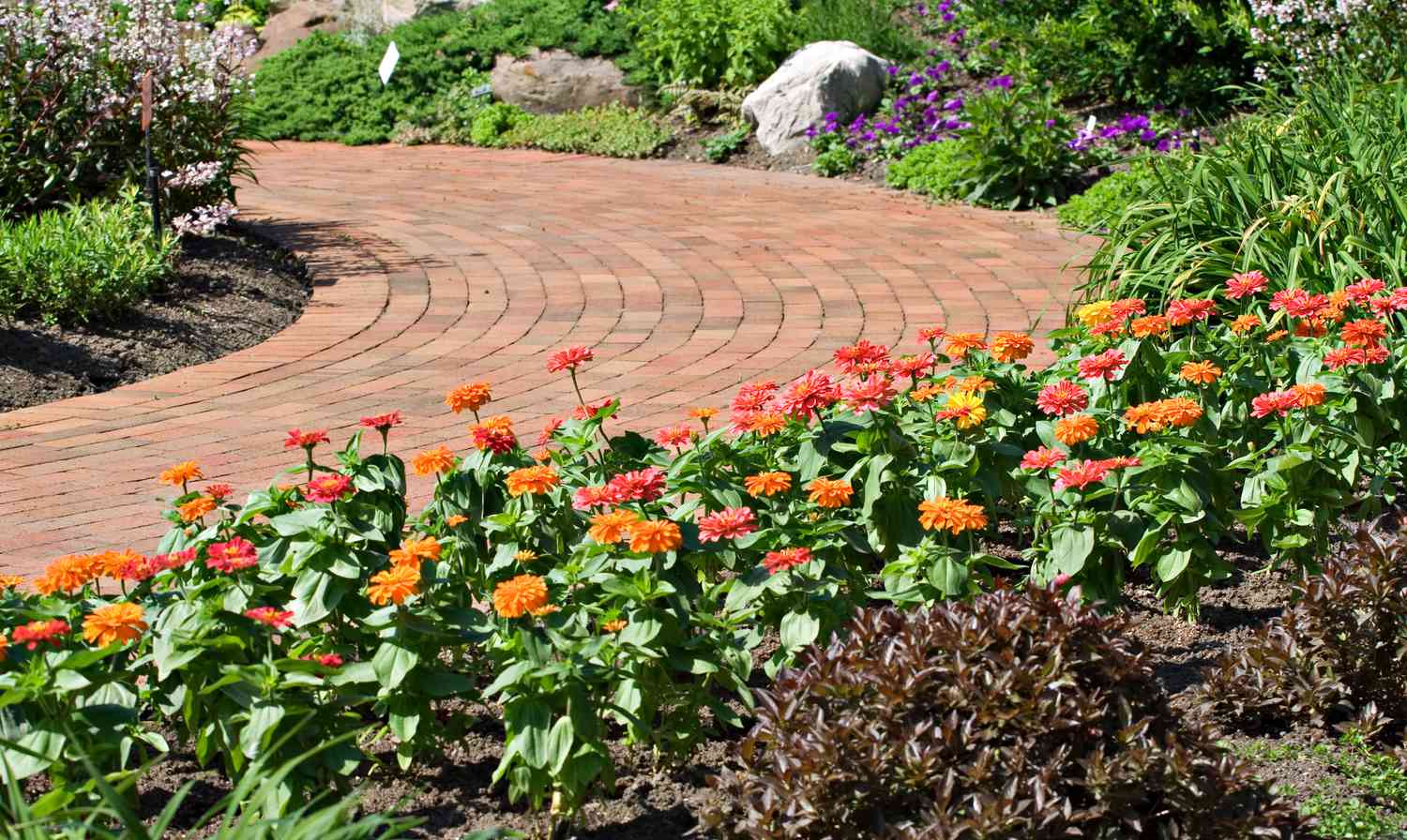 A beautiful brick walking path through a garden.