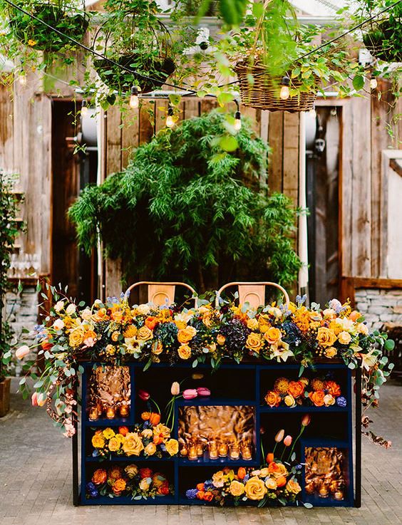 sweetheart table outdoor bookcase with orange flower arrangements