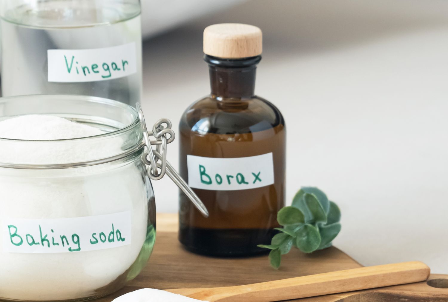 Containers of vinegar baking soda and borax on a countertop