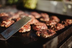 Outdoor cookout with burgers on a grill