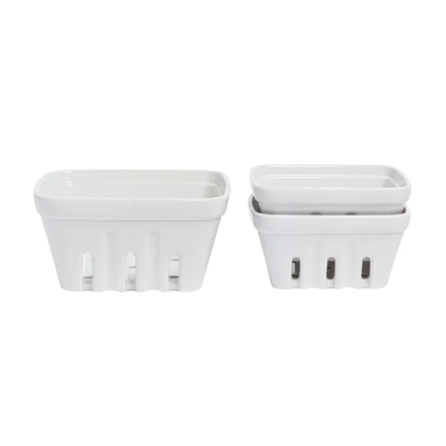 Two white ceramic containers shaped like baskets each having rectangular slots on the sides