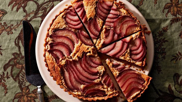 poached-pear frangipane tart on decorative green table cloth